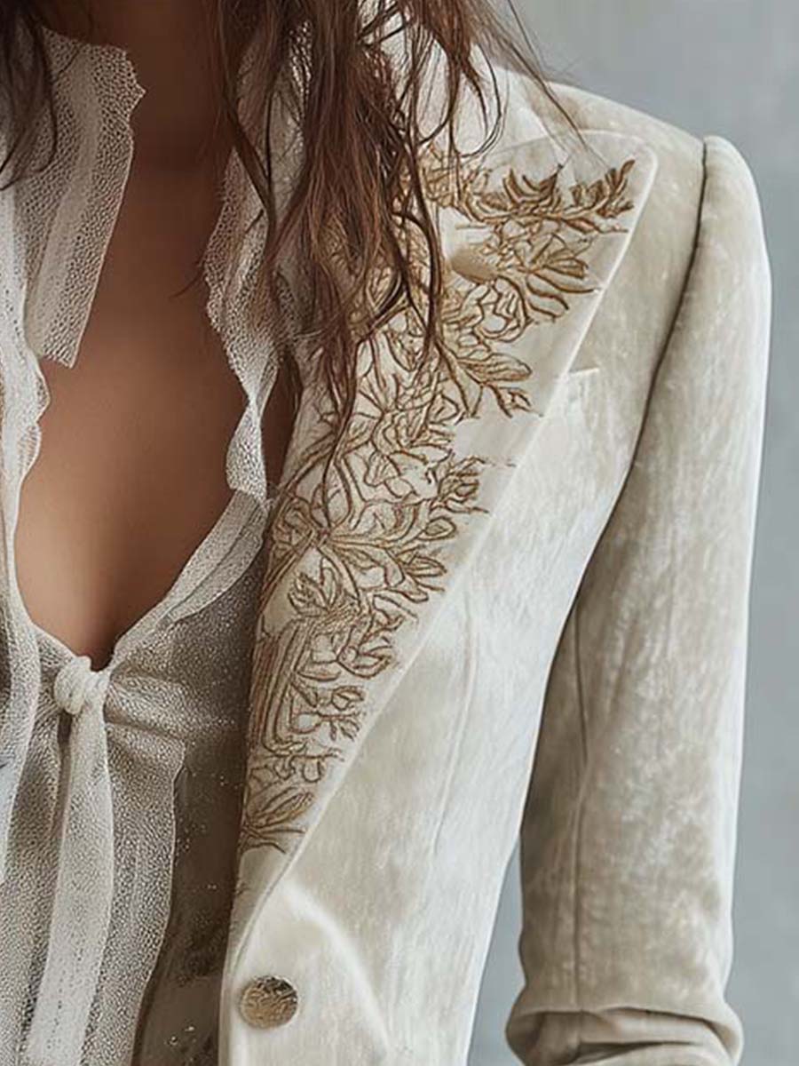 Kristin blazer med broderat slag och guldfärgad knapp, närbild