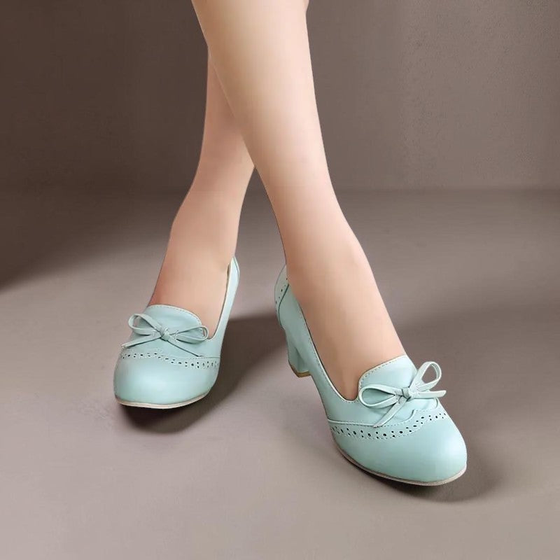 Marie-Louise – eleganta slip-on-pumps med rosett i blått, på benen