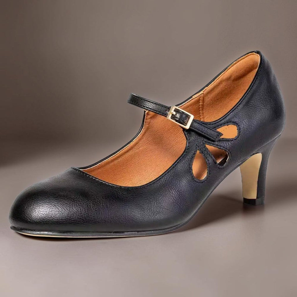 Ingmarie svarta pumps med sluten tå, ankelrem och utskurna detaljer, snett framifrån